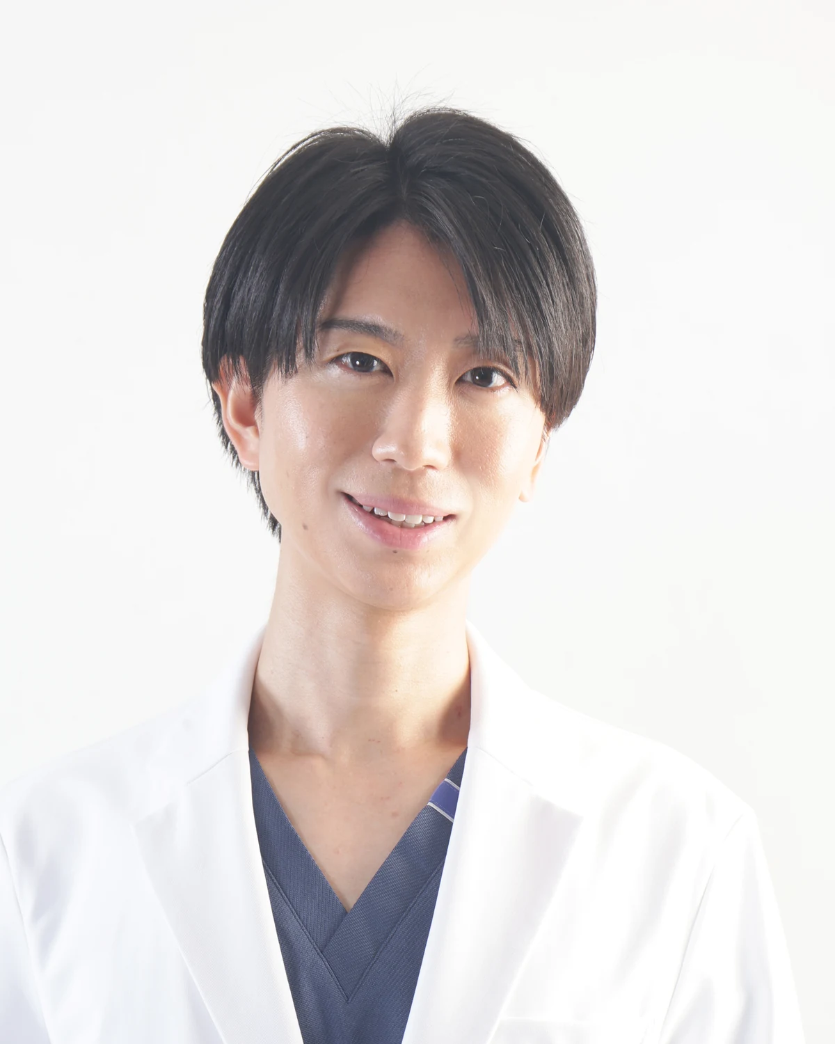 白衣とスクラブを着用した形成外科医・辛川領のポートレート